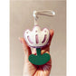 Hand holding the tulip-shaped keychain with a blurred background
