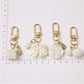 Keypus keychain featuring a pink beaded bow charm attached to a gold keyring on white background