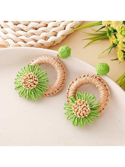 Model wearing Earedge raffia daisy shaped stud earrings close to ear