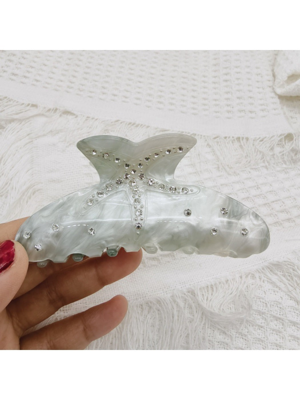 Beau rainbow claw clip resting on a white surface with natural lighting
