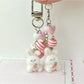 Pink bunny keychain hanging from a set of keys on a wooden surface