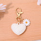 Red leather heart shaped keychain with gold hardware placed on a wooden table