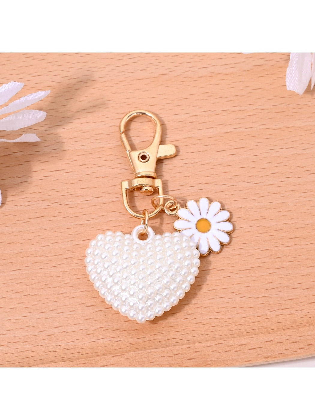 Red leather heart shaped keychain with gold hardware placed on a wooden table