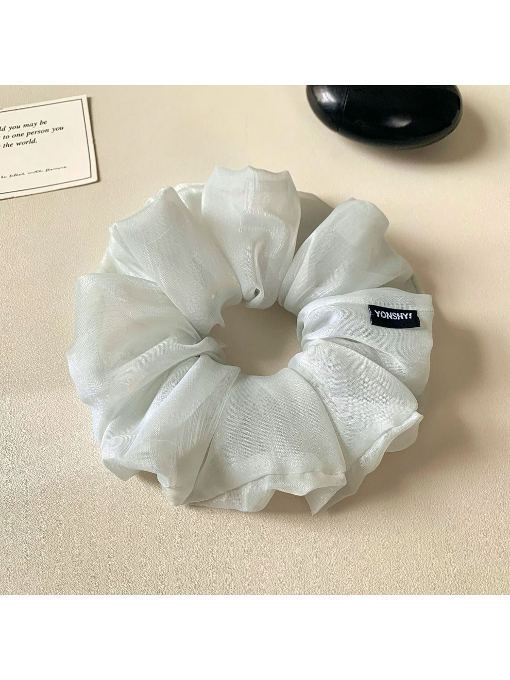Grey ruched scrunchie styled on a wrist as a fashion accessory
