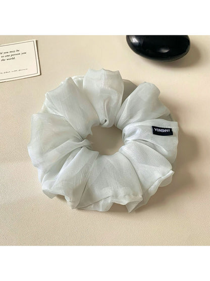 Grey ruched scrunchie styled on a wrist as a fashion accessory