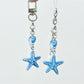 Starfish pendant keychain hanging from a bag zipper