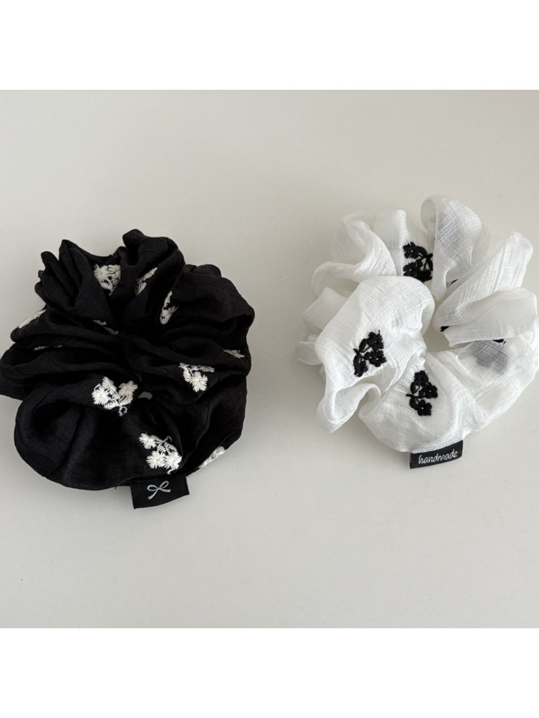 Close-up of Gifty scrunchie with gentle floral pattern on soft fabric
