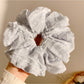 Gifty scrunchie stretched to show elastic band inside ruched fabric