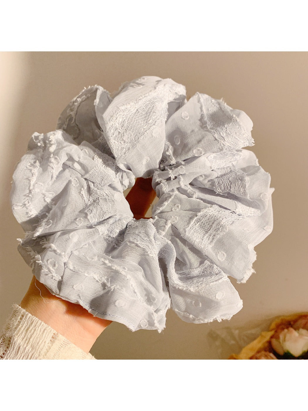 Gifty scrunchie stretched to show elastic band inside ruched fabric