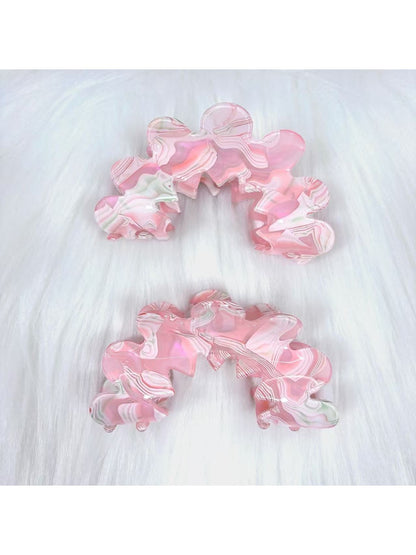 Close-up of Beau wavy pink hair clip with glossy finish on white background
