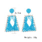 Side view of raffia woven trapezoid earrings showing texture and weave
