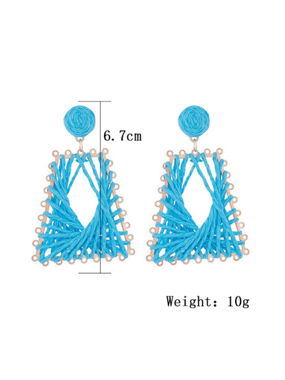 Side view of raffia woven trapezoid earrings showing texture and weave