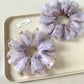 Purple printed scrunchie displayed on a white background showing fabric texture