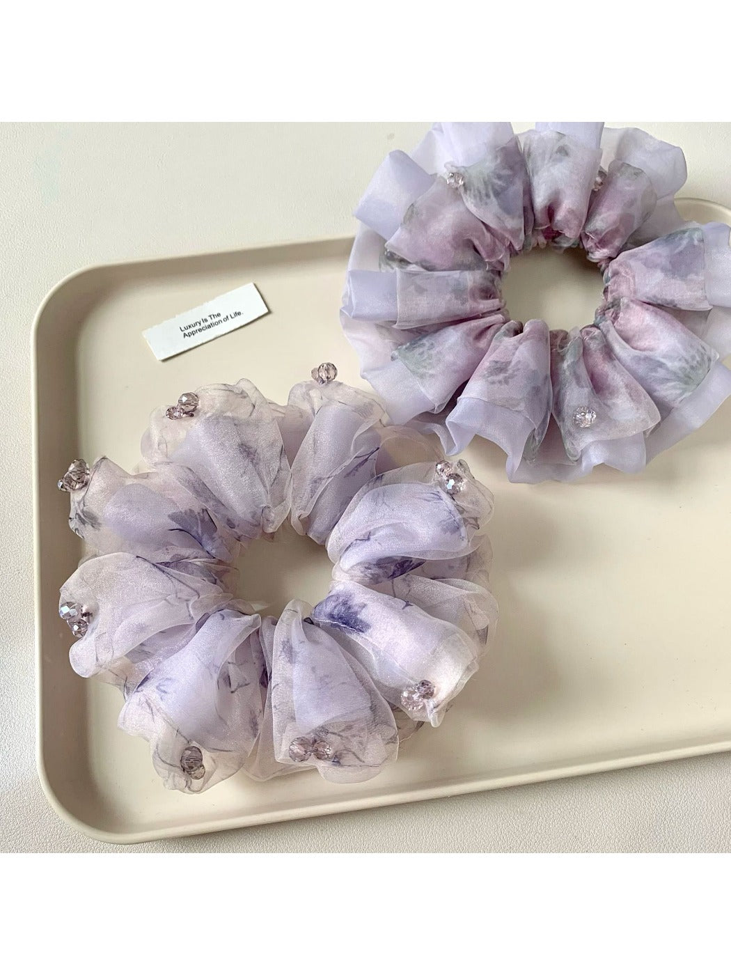 Purple printed scrunchie displayed on a white background showing fabric texture
