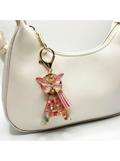 Hand holding the butterfly letter pendant keychain showing details
