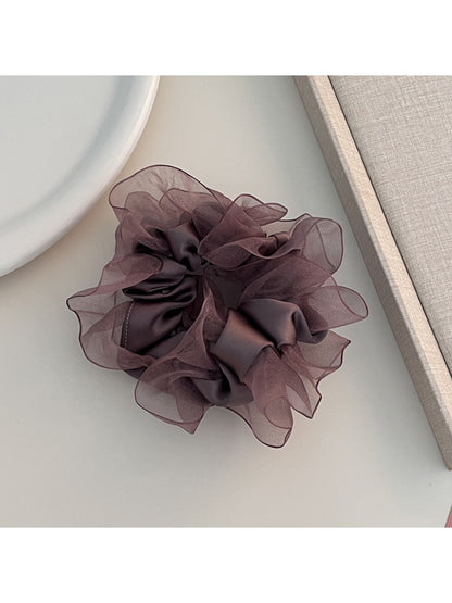 Ruffled scrunchie worn on the wrist as a stylish accessory