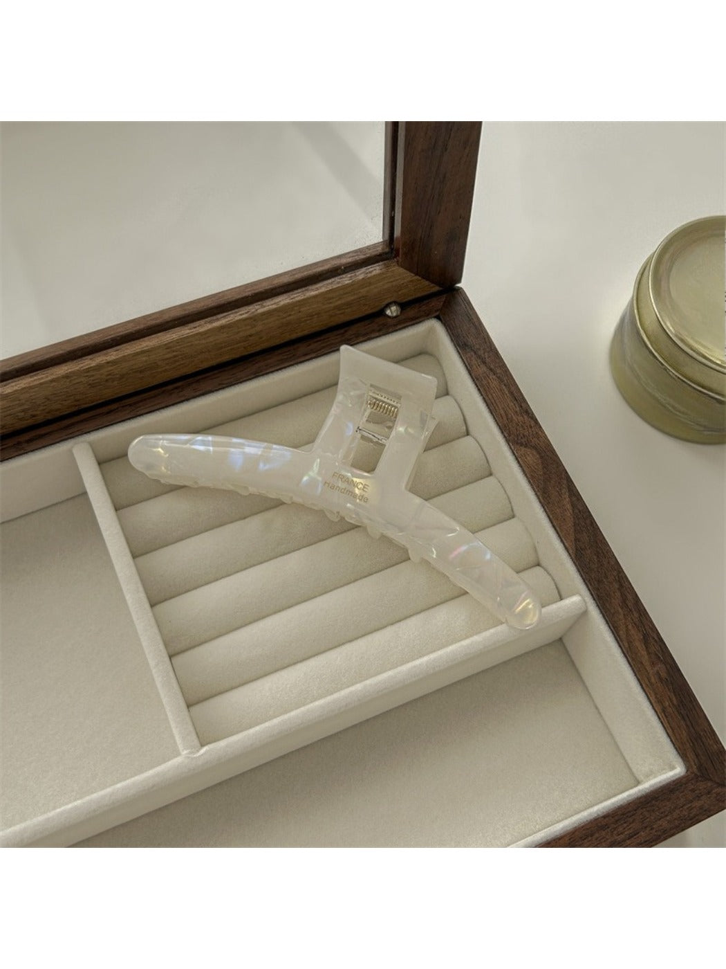 Beau claw clip placed on a wooden surface with natural light highlighting texture