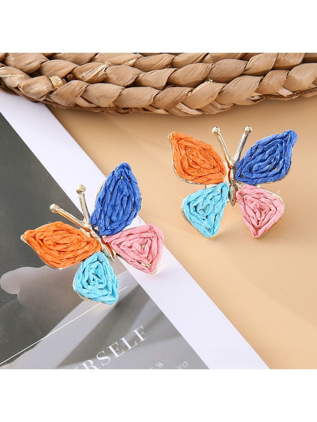 Model wearing Earedge butterfly shaped drop earrings with a black top