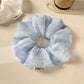 Top view of a solid color ruched scrunchie showing gathered fabric details
