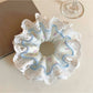 Close-up of Gifty double layer tiny floral lace scrunchie in soft pink