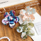 Side view of multicolored flower hair claw clip highlighting curved petals and grip