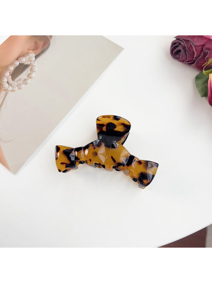 Model showing side profile with Beau bow shaped claw clip in hair
