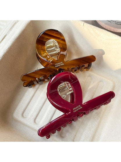 Side view of Beau acetate claw clip highlighting its curved bar shape design