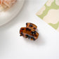 Beau hair clip placed on fabric surface highlighting texture and colors