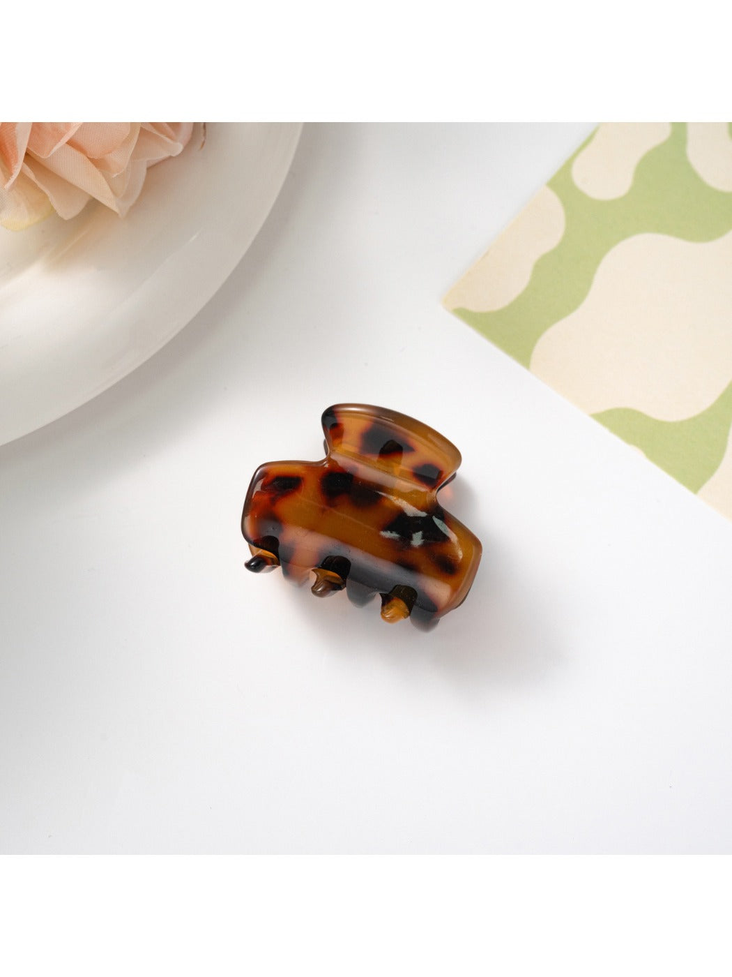 Beau hair clip placed on fabric surface highlighting texture and colors