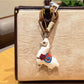 Alpaca charm keychain displayed with other colorful keychains on a hook