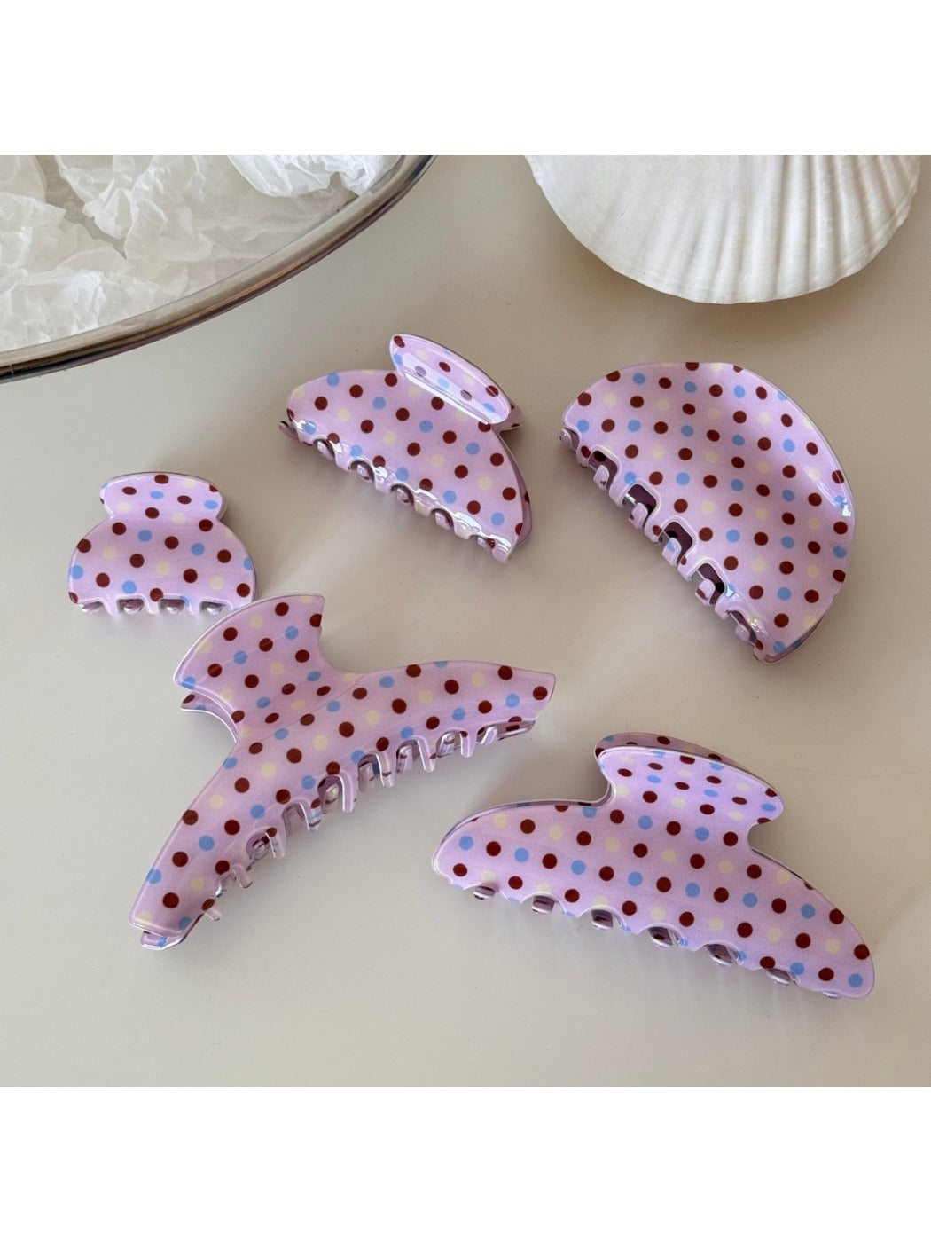 Beau pink polka dot hair clip held in hand showing size and detail