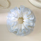 Gifty tulle ruffle scrunchie styled on a wrist with delicate ruffled texture
