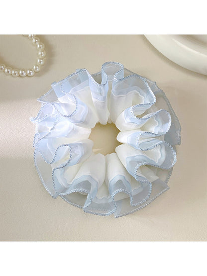Gifty tulle ruffle scrunchie styled on a wrist with delicate ruffled texture