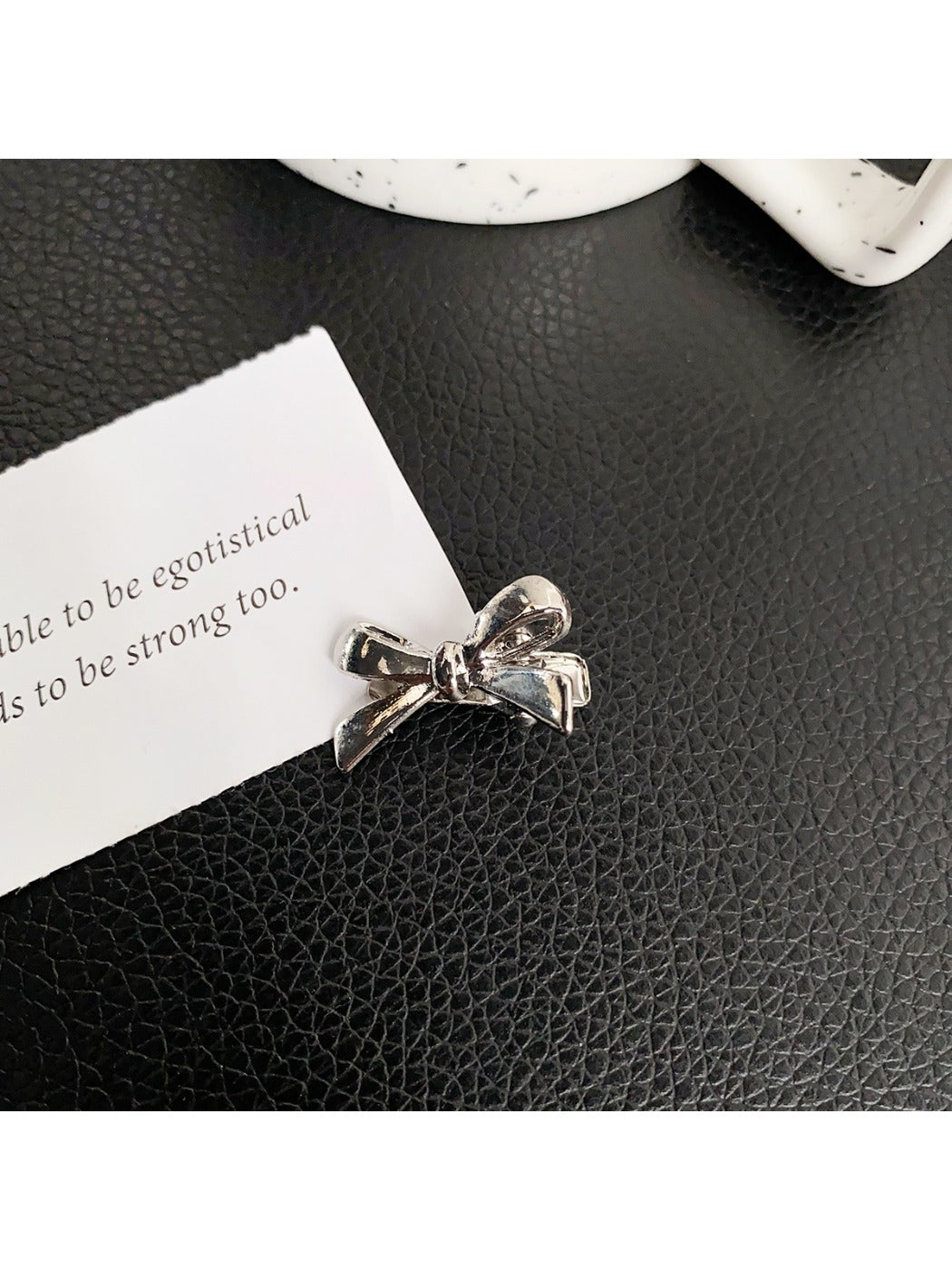 Beau classic bow hair clip held in hand showing size relative to fingers