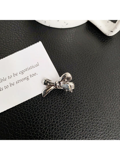 Beau classic bow hair clip held in hand showing size relative to fingers