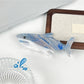 Beau minimalist shark hair claw clip displayed on a wooden surface