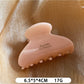 Beau Sweet Chic acetate claw clip resting on a wooden surface
