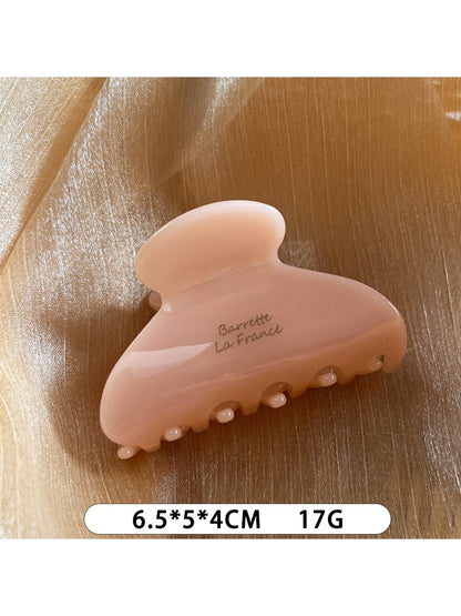 Beau Sweet Chic acetate claw clip resting on a wooden surface