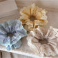 Close-up of Gifty lace scrunchie showing delicate floral lace texture in soft fabric