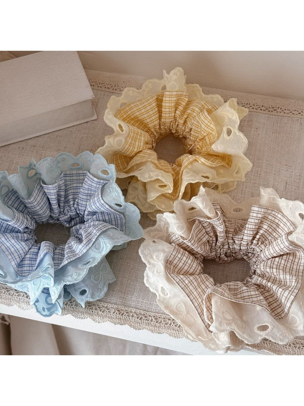 Close-up of Gifty lace scrunchie showing delicate floral lace texture in soft fabric