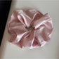 Gifty satin scrunchie with rhinestones shown in natural light highlighting texture