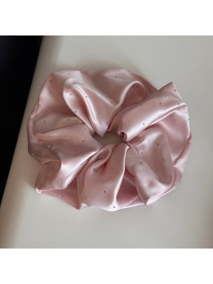Gifty satin scrunchie with rhinestones shown in natural light highlighting texture
