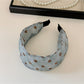 Flat lay of blue polka dot headband and scrunchie with gift box