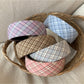 Wide plaid headband in beige and brown tones displayed on a white background
