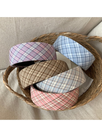 Wide plaid headband in beige and brown tones displayed on a white background