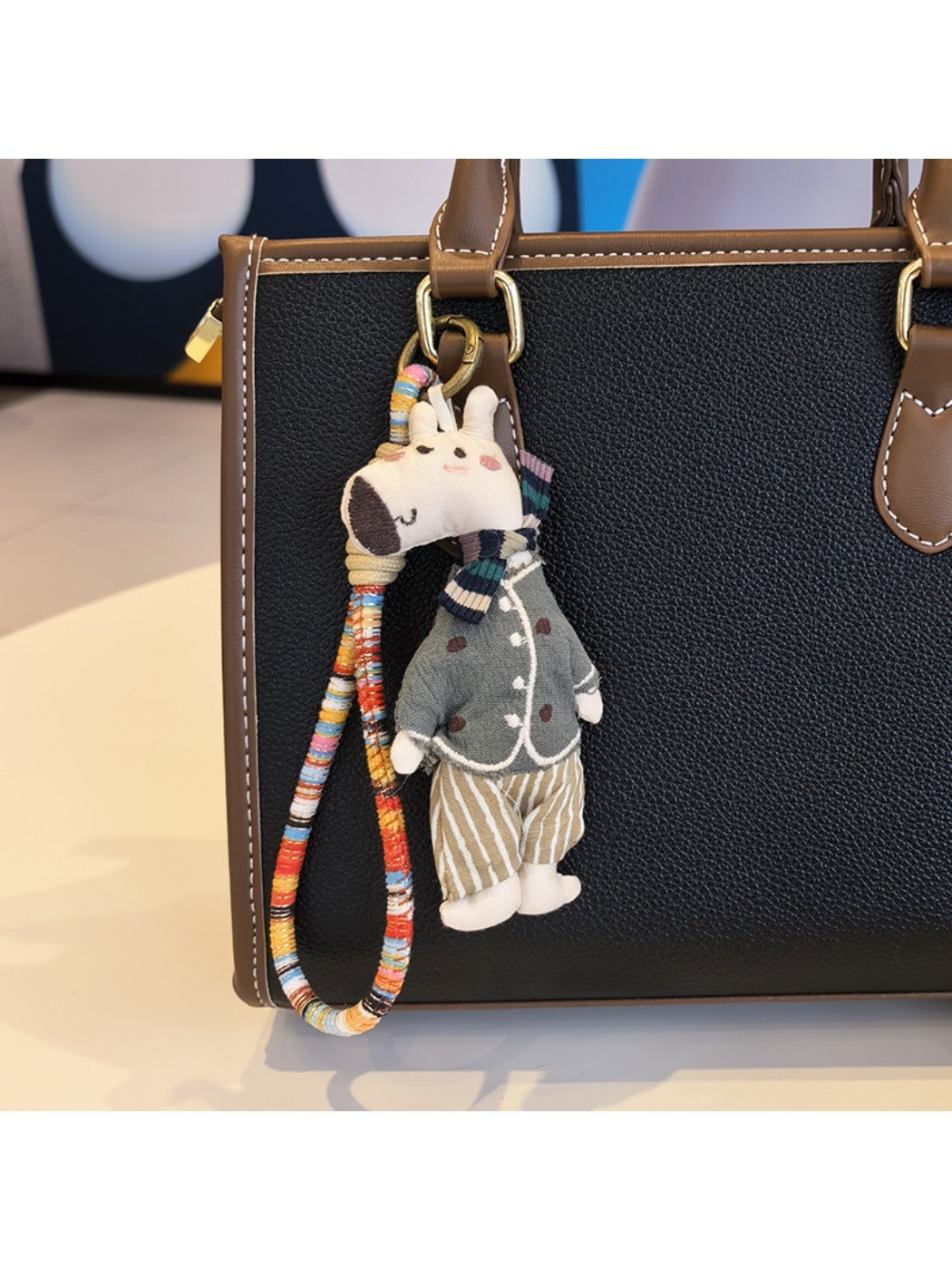 Giraffe charm keychain next to a small plant for scale