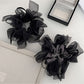 Close-up of Gifty dark large bow scrunchie on a white background