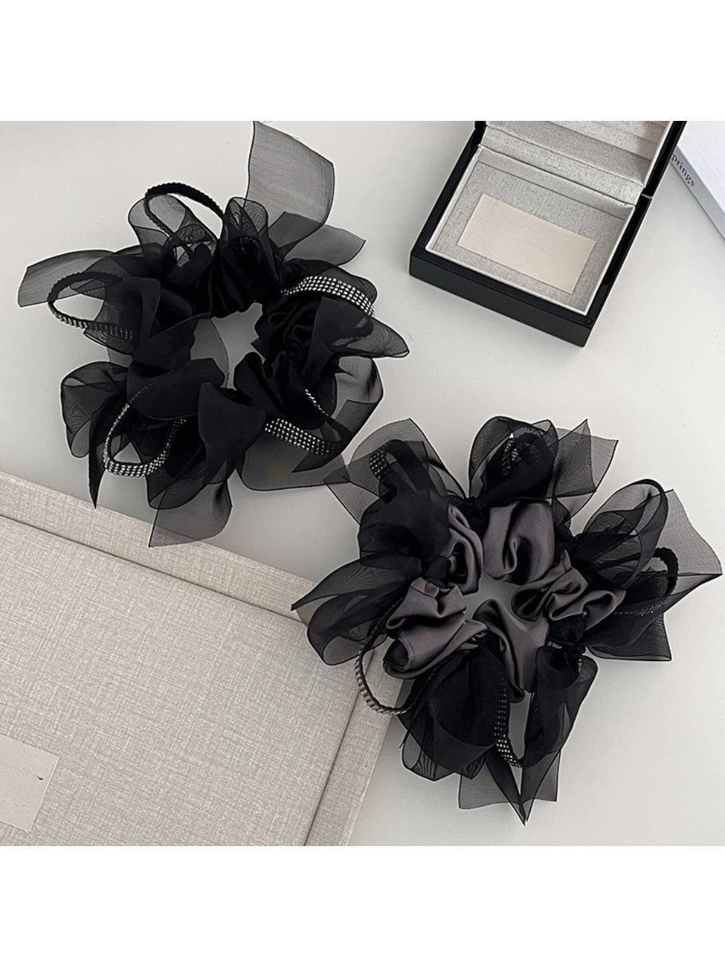 Close-up of Gifty dark large bow scrunchie on a white background