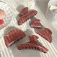 Close-up of Beau hair claw clip showing red strawberries on plaid background