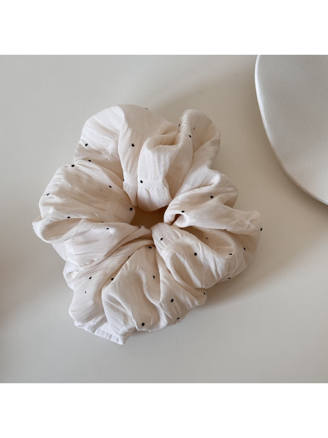 Gifty soft polka dot scrunchie styled on a wrist as a fashion accessory